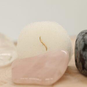 Kunstzinnige zandsculptuur met goudaccent, minimalistisch ontwerp.