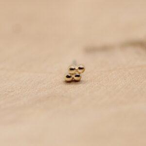 Ember Rhombus body piercing met glanzende metalen bolletjes, minimalistisch ontwerp.